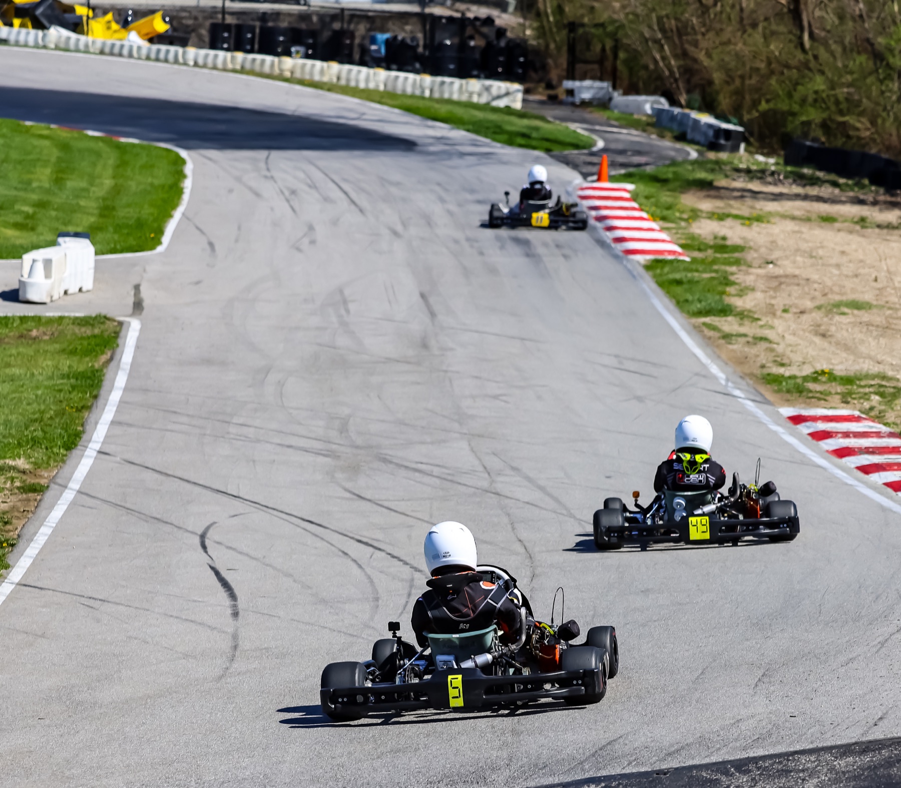 Junior kart racers climbing the circuit in formation